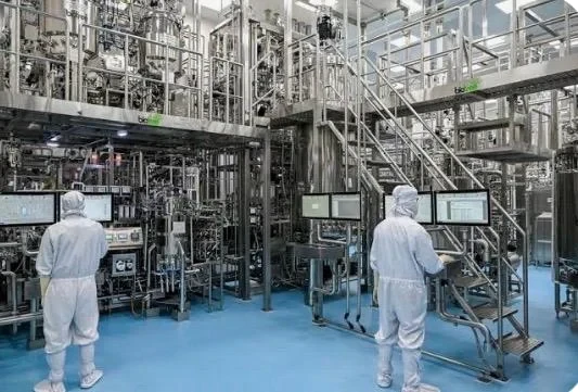 Technicians in cleanroom suits at a pharmaceutical production facility