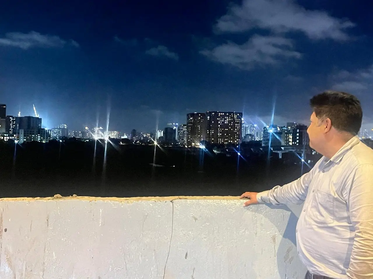 Shubham Kaushik looking out over a city skyline at night